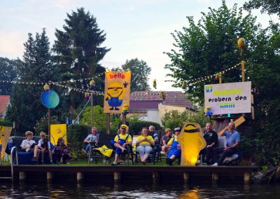 August 2024 Korsofahrt in Alt Ruppin | geschmücktes Ufer des Rhin bei Dämmerung