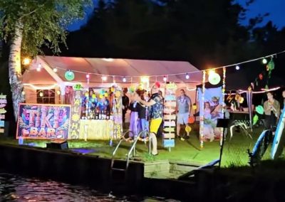 August 2024 Korsofahrt in Alt Ruppin | geschmücktes Ufer des Rhin bei Nacht mit Lichterkette und Party